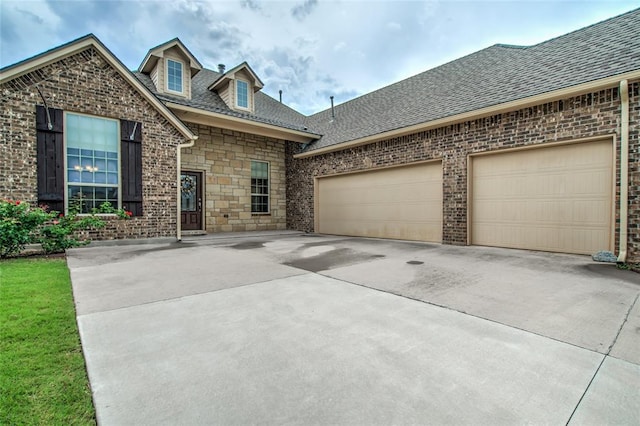 2717 Cordgrass Ln, Edmond, OK 73013 - view of front of house with driveway, roof with shingles, a garage, brick siding, and stone siding