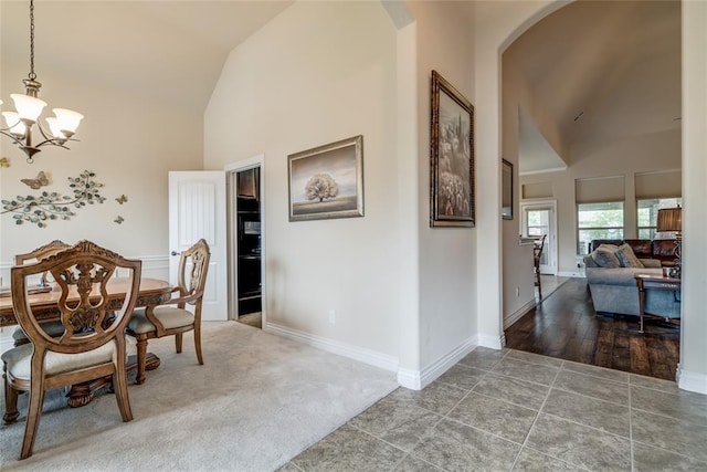 2717 Cordgrass Ln, Edmond, OK 73013 - tiled dining area with a chandelier, high vaulted ceiling, arched walkways, and baseboards