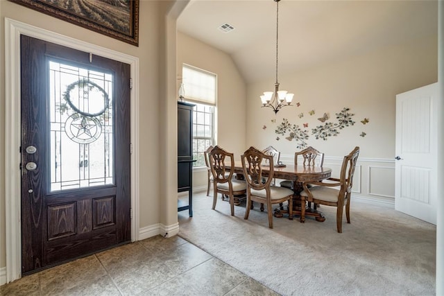 2717 Cordgrass Ln, Edmond, OK 73013 - foyer with light carpet, a chandelier, lofted ceiling, a wainscoted wall, and arched walkways