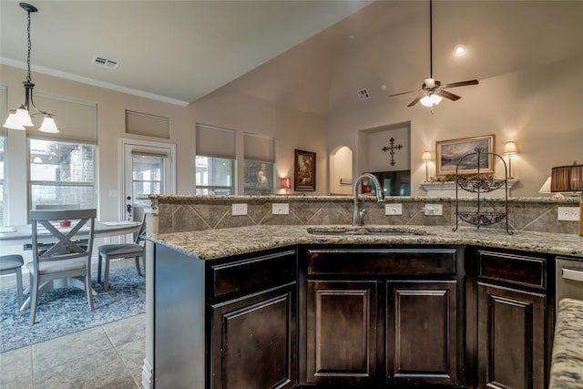 2717 Cordgrass Ln, Edmond, OK 73013 - kitchen featuring a sink, a ceiling fan, light stone counters, dark brown cabinets, and ornamental molding