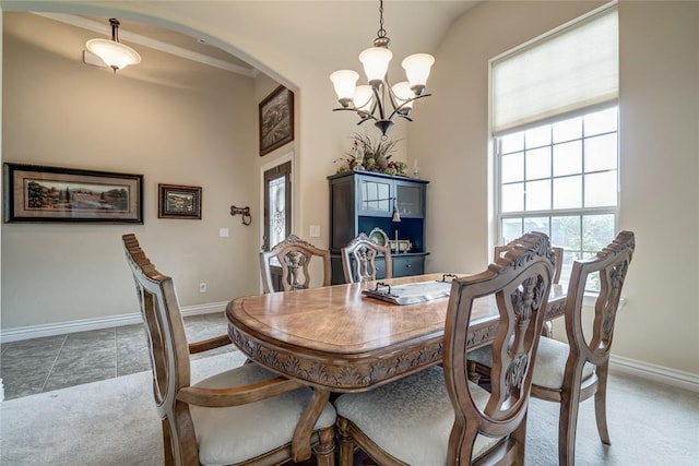 2717 Cordgrass Ln, Edmond, OK 73013 - tiled dining space with a chandelier, carpet flooring, arched walkways, and baseboards