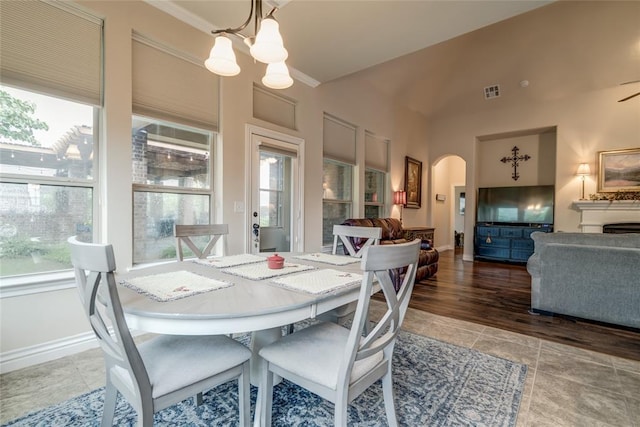 2717 Cordgrass Ln, Edmond, OK 73013 - tiled dining room with arched walkways, a chandelier, baseboards, and crown molding