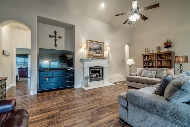 2717 Cordgrass Ln, Edmond, OK 73013 - living area with arched walkways, dark wood-style flooring, ceiling fan, and high vaulted ceiling
