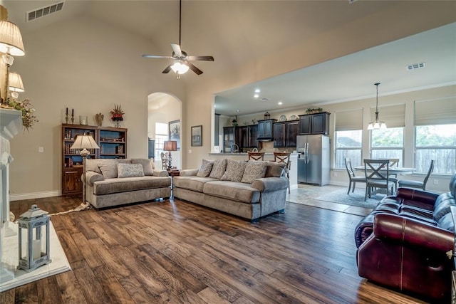 2717 Cordgrass Ln, Edmond, OK 73013 - living room featuring ceiling fan, arched walkways, wood finished floors, vaulted ceiling, and baseboards