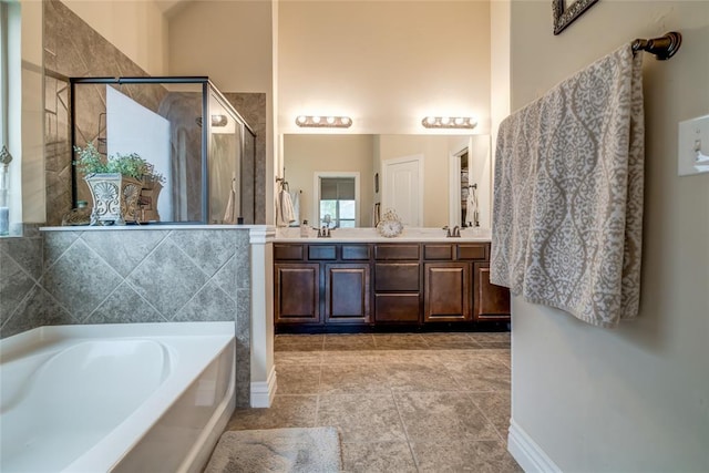 2717 Cordgrass Ln, Edmond, OK 73013 - bathroom featuring a bath, a shower stall, double vanity, tile patterned flooring, and baseboards