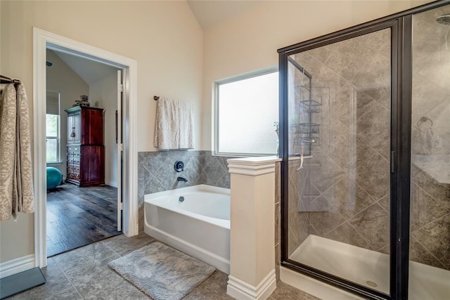 2717 Cordgrass Ln, Edmond, OK 73013 - bathroom with vaulted ceiling, a garden tub, healthy amount of natural light, a shower stall, and baseboards