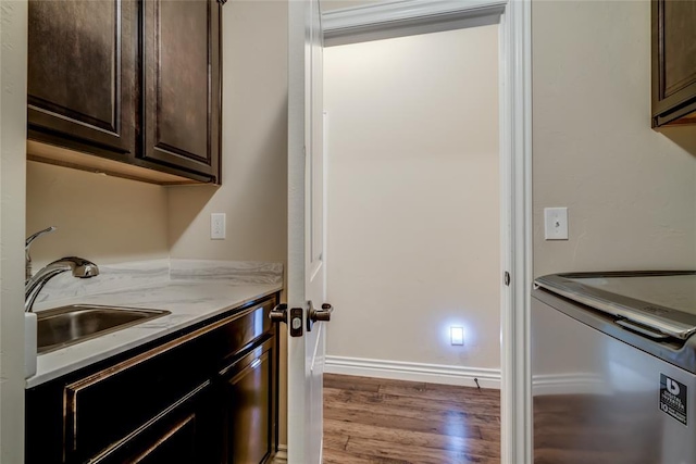 2717 Cordgrass Ln, Edmond, OK 73013 - laundry room featuring cabinet space, wood finished floors, and baseboards