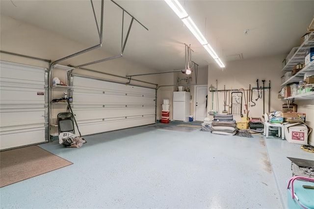 2717 Cordgrass Ln, Edmond, OK 73013 - garage with freestanding refrigerator and a garage door opener