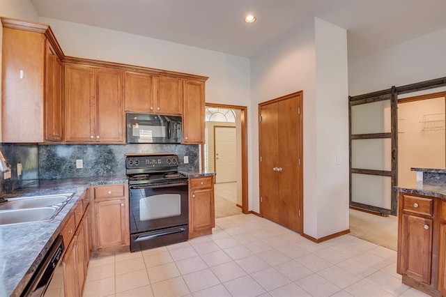 832 Elm Creek Dr, Moore, OK 73160 - kitchen with black appliances, a sink, decorative backsplash, brown cabinetry, and dark countertops