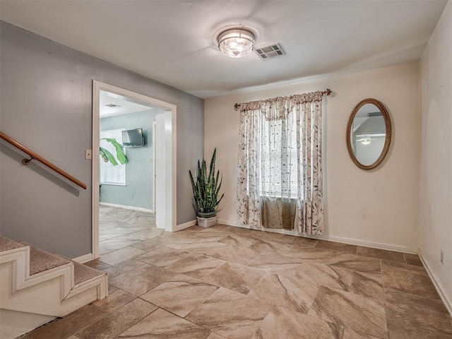 2604 Jeannes Trl, Edmond, OK 73012 - empty room with stone finish floors, stairs, and baseboards