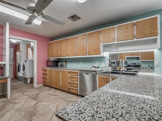 2604 Jeannes Trl, Edmond, OK 73012 - kitchen with appliances with stainless steel finishes, washer and clothes dryer, a ceiling fan, a sink, and light stone counters