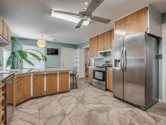 2604 Jeannes Trl, Edmond, OK 73012 - kitchen featuring appliances with stainless steel finishes, a ceiling fan, a peninsula, and light stone counters