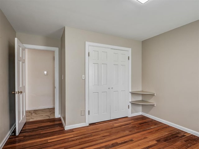 2604 Jeannes Trl, Edmond, OK 73012 - unfurnished bedroom featuring wood finished floors, a closet, and baseboards