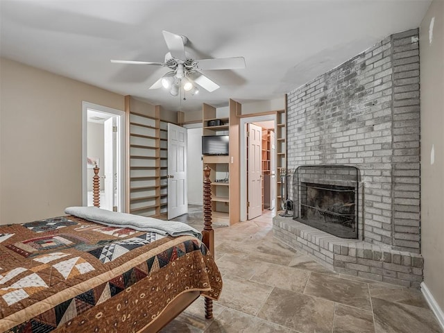 2604 Jeannes Trl, Edmond, OK 73012 - bedroom with a brick fireplace, a spacious closet, ceiling fan, and stone finish floors