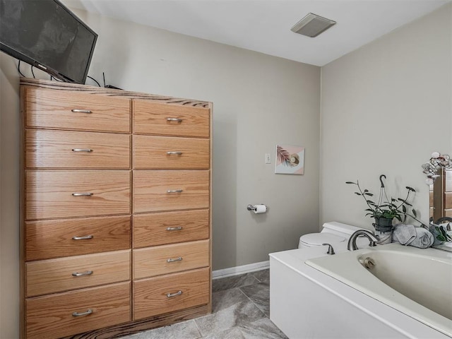 2604 Jeannes Trl, Edmond, OK 73012 - full bathroom featuring baseboards, toilet, and a garden tub