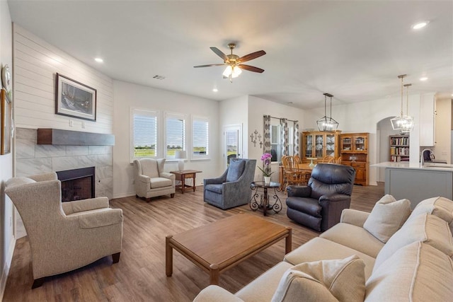 29731 Jade St, Cashion, OK 73016 - living area with ceiling fan, a fireplace, wood finished floors, recessed lighting, and arched walkways