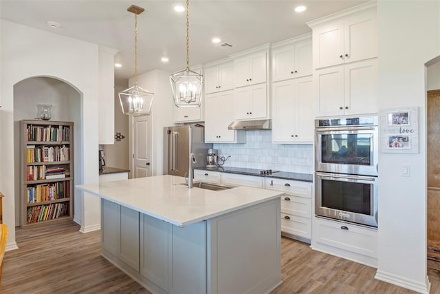 29731 Jade St, Cashion, OK 73016 - kitchen with appliances with stainless steel finishes, light wood-type flooring, decorative backsplash, white cabinetry, and recessed lighting