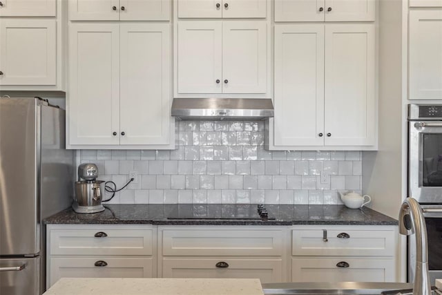 29731 Jade St, Cashion, OK 73016 - kitchen with freestanding refrigerator, exhaust hood, black electric stovetop, white cabinetry, and dark stone countertops