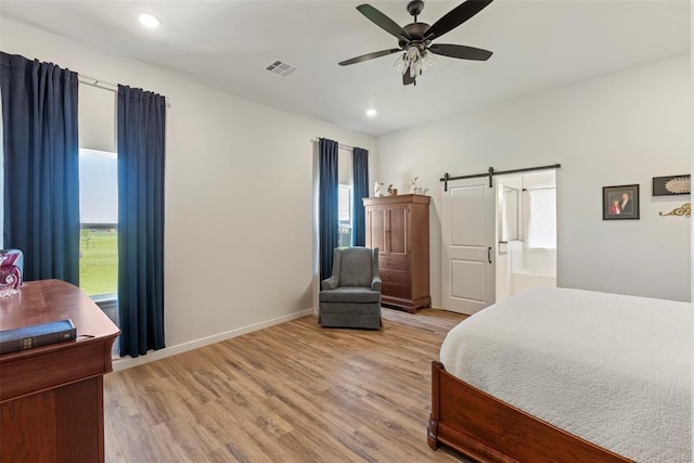 29731 Jade St, Cashion, OK 73016 - bedroom featuring a barn door, multiple windows, light wood-style floors, recessed lighting, and a ceiling fan