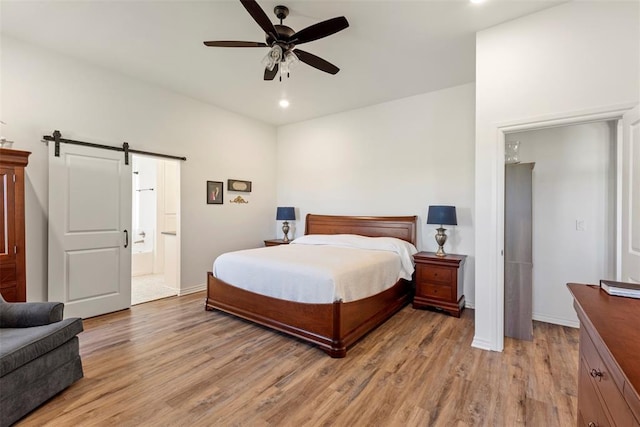 29731 Jade St, Cashion, OK 73016 - bedroom featuring a barn door, light wood finished floors, connected bathroom, recessed lighting, and ceiling fan