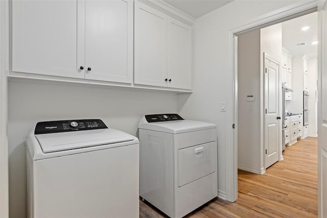 29731 Jade St, Cashion, OK 73016 - laundry area with washing machine and clothes dryer, cabinet space, and light wood finished floors