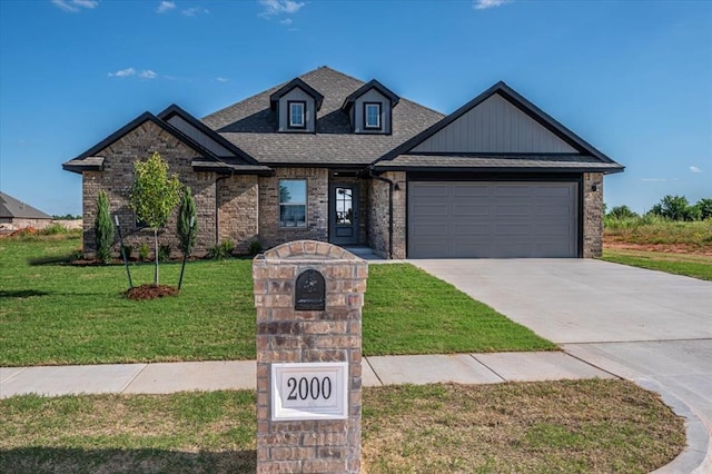 2000 W Flintlock Way, Mustang, OK 73065 - view of front of property with concrete driveway, a garage, a front lawn, brick siding, and a shingled roof