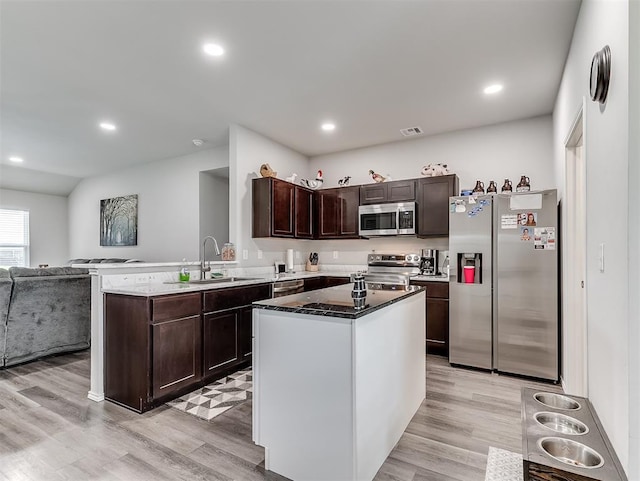 42173 N Max Henry Dr, Shawnee, OK 74804 - kitchen featuring appliances with stainless steel finishes, a sink, dark brown cabinets, open floor plan, and light wood-type flooring