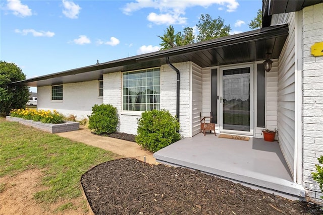2020 Lyle Rd, Weatherford, OK 73096 - property entrance with brick siding, a patio area, and a lawn