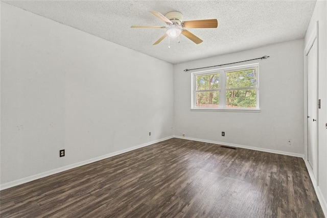 2020 Lyle Rd, Weatherford, OK 73096 - empty room featuring a textured ceiling, dark wood-style floors, a ceiling fan, and baseboards