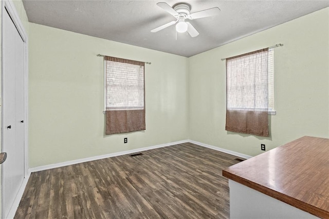 2020 Lyle Rd, Weatherford, OK 73096 - empty room with healthy amount of natural light, dark wood finished floors, ceiling fan, and baseboards