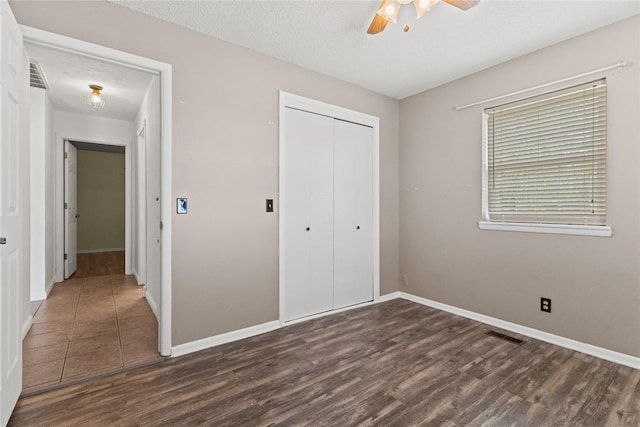 2020 Lyle Rd, Weatherford, OK 73096 - unfurnished bedroom featuring wood finished floors, a closet, baseboards, ceiling fan, and a textured ceiling