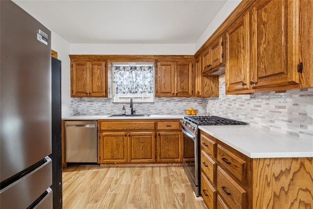 201 Vine St, Yukon, OK 73099 - kitchen featuring appliances with stainless steel finishes, a sink, brown cabinets, and light countertops