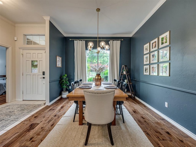13925 Middleberry Rd, Edmond, OK 73013 - dining room with wood finished floors, a chandelier, crown molding, and baseboards