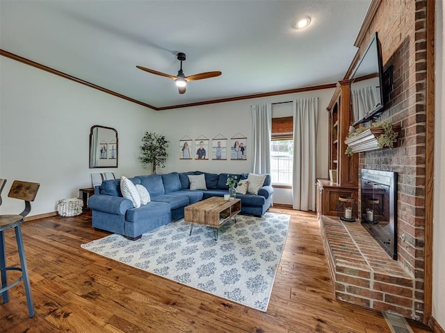 13925 Middleberry Rd, Edmond, OK 73013 - living area with crown molding, a brick fireplace, a ceiling fan, wood finished floors, and baseboards