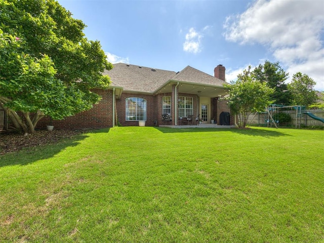 13925 Middleberry Rd, Edmond, OK 73013 - rear view of house with a chimney, a playground, brick siding, and a patio area