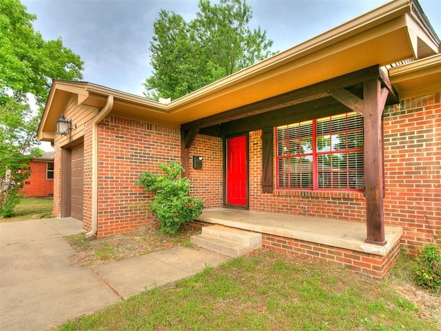 1545 N Pennsylvania Ave, Shawnee, OK 74804 - view of exterior entry featuring brick siding, a garage, and driveway