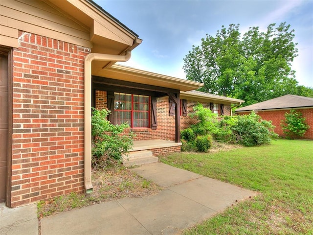 1545 N Pennsylvania Ave, Shawnee, OK 74804 - property entrance with brick siding, a yard, and covered porch