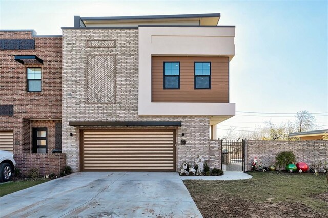 571 S Fretz Ave, Edmond, OK 73003 - modern home featuring brick siding, a garage, driveway, and a gate