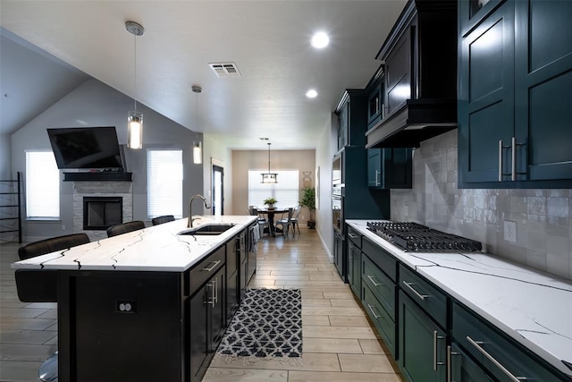 8725 NW Kensington Pl, Lawton, OK 73505 - kitchen with a sink, gas stovetop, open floor plan, backsplash, and a kitchen island with sink