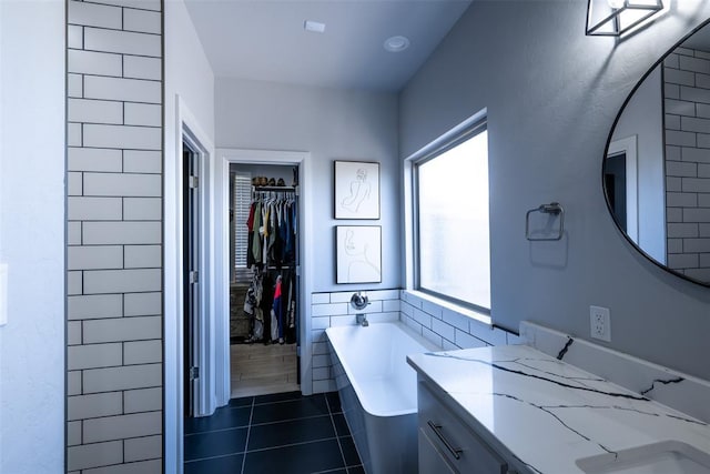 8725 NW Kensington Pl, Lawton, OK 73505 - full bathroom with a bath, a spacious closet, tile patterned flooring, and vanity
