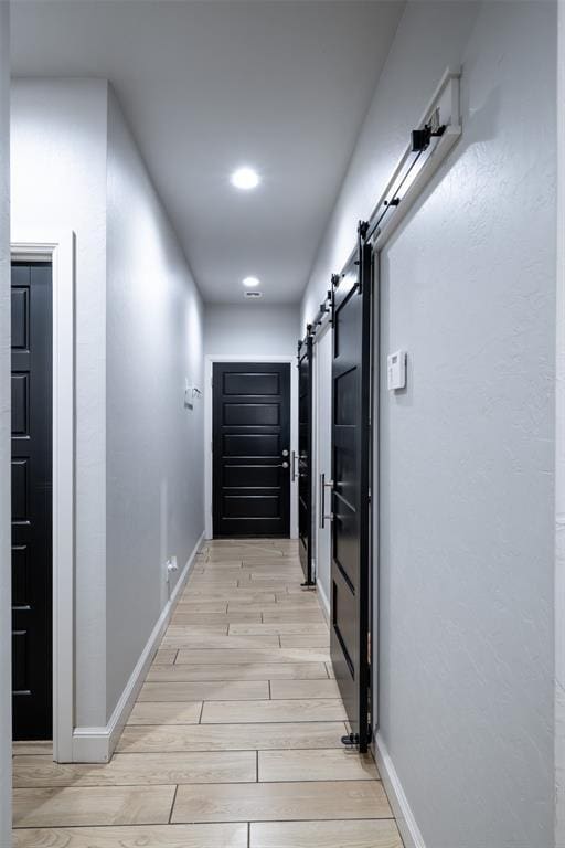8725 NW Kensington Pl, Lawton, OK 73505 - corridor with a barn door, light wood-type flooring, baseboards, and recessed lighting