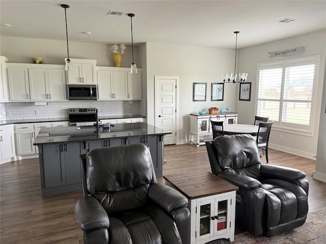 2320 Dixie Dr, Blanchard, OK 73010 - kitchen featuring stainless steel microwave, electric range oven, tasteful backsplash, and a chandelier