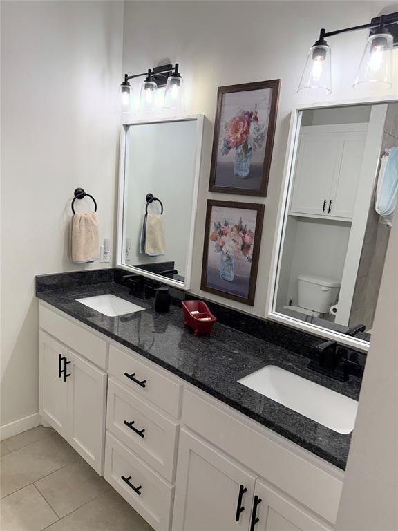 2320 Dixie Dr, Blanchard, OK 73010 - bathroom with double vanity, toilet, tile patterned floors, and baseboards