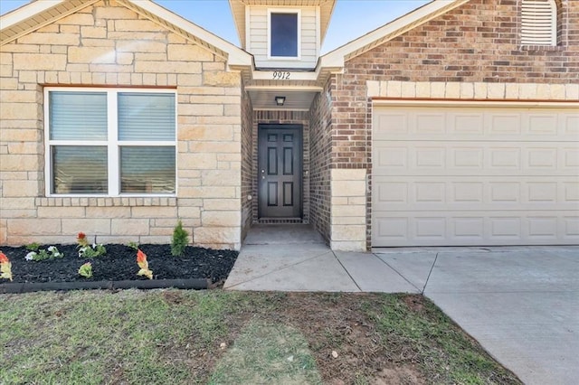 9912 Ruger Rd, Yukon, OK 73099 - doorway to property with an attached garage and brick siding