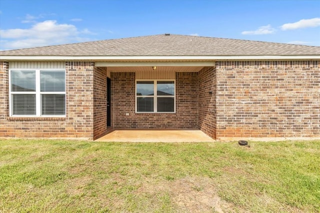 9912 Ruger Rd, Yukon, OK 73099 - rear view of property featuring a yard, brick siding, a patio area, and roof with shingles