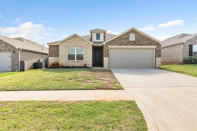 9912 Ruger Rd, Yukon, OK 73099 - view of front facade featuring central AC unit, a garage, driveway, a front lawn, and stone siding
