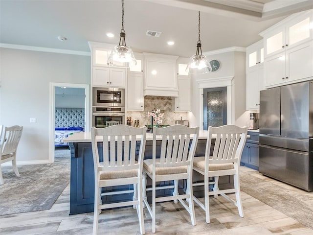 3317 Open Prairie Trl, Yukon, OK 73099 - kitchen featuring appliances with stainless steel finishes, crown molding, white cabinetry, light countertops, and a center island with sink