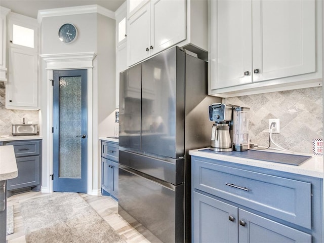 3317 Open Prairie Trl, Yukon, OK 73099 - kitchen featuring freestanding refrigerator, tasteful backsplash, ornamental molding, light countertops, and white cabinets