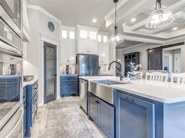 3317 Open Prairie Trl, Yukon, OK 73099 - kitchen featuring a sink, crown molding, blue cabinetry, appliances with stainless steel finishes, and a barn door