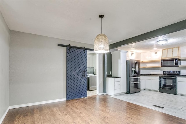 816 Woodbury Dr, Edmond, OK 73034 - kitchen with stainless steel appliances, dark countertops, a barn door, tasteful backsplash, and white cabinets